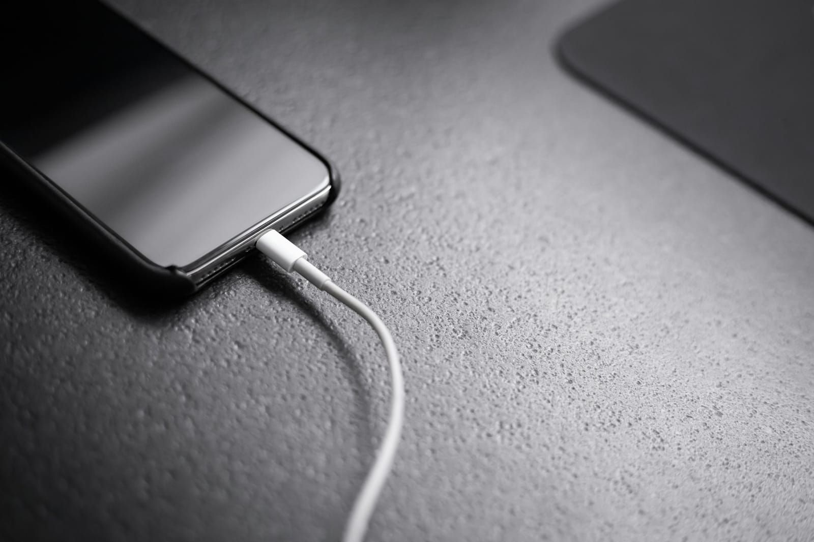 iPhone mit angeschlossenem Ladekabel