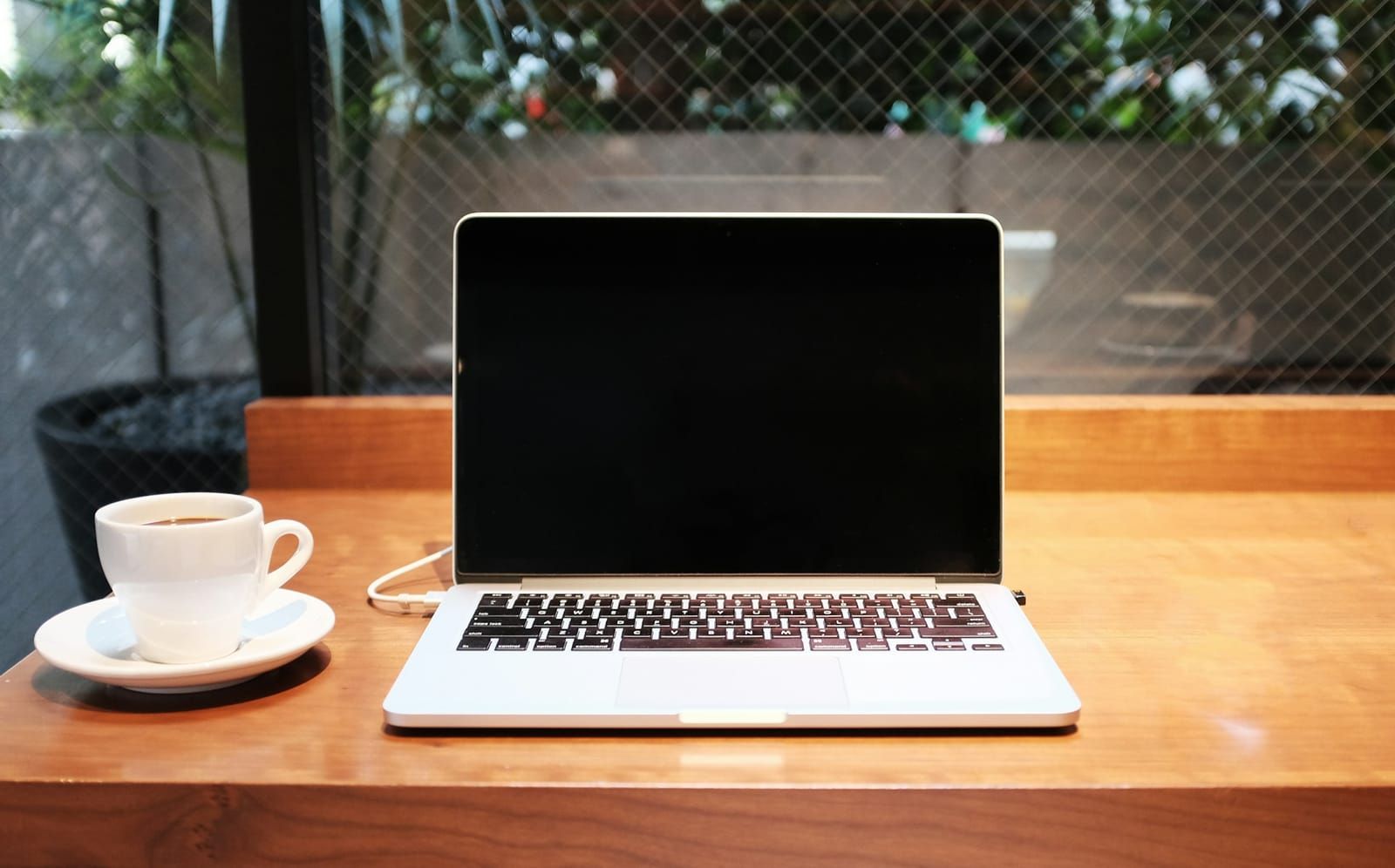 MacBook neben einer Kaffeetasse